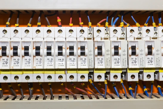 Intérieur d'un tableau électrique professionnel avec rangées de disjoncteurs modulaires installés sur rail DIN