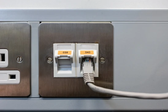 Panneau de connexion réseau mural avec prises RJ45 étiquetées 039 et 040, câble Ethernet blanc connecté